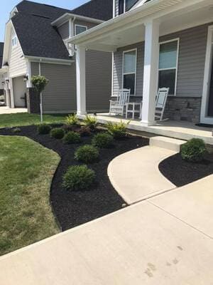 Fresh mulch + shrubs on a covered front porch